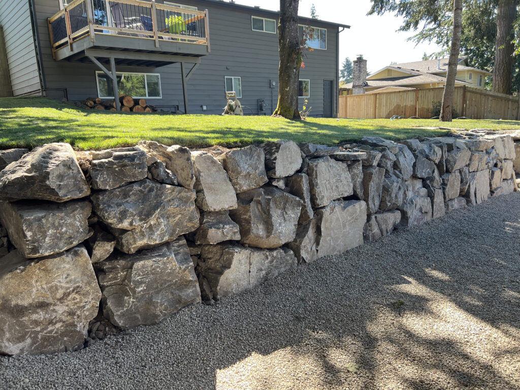 Renton WA rock retaining wall with raised lawn area