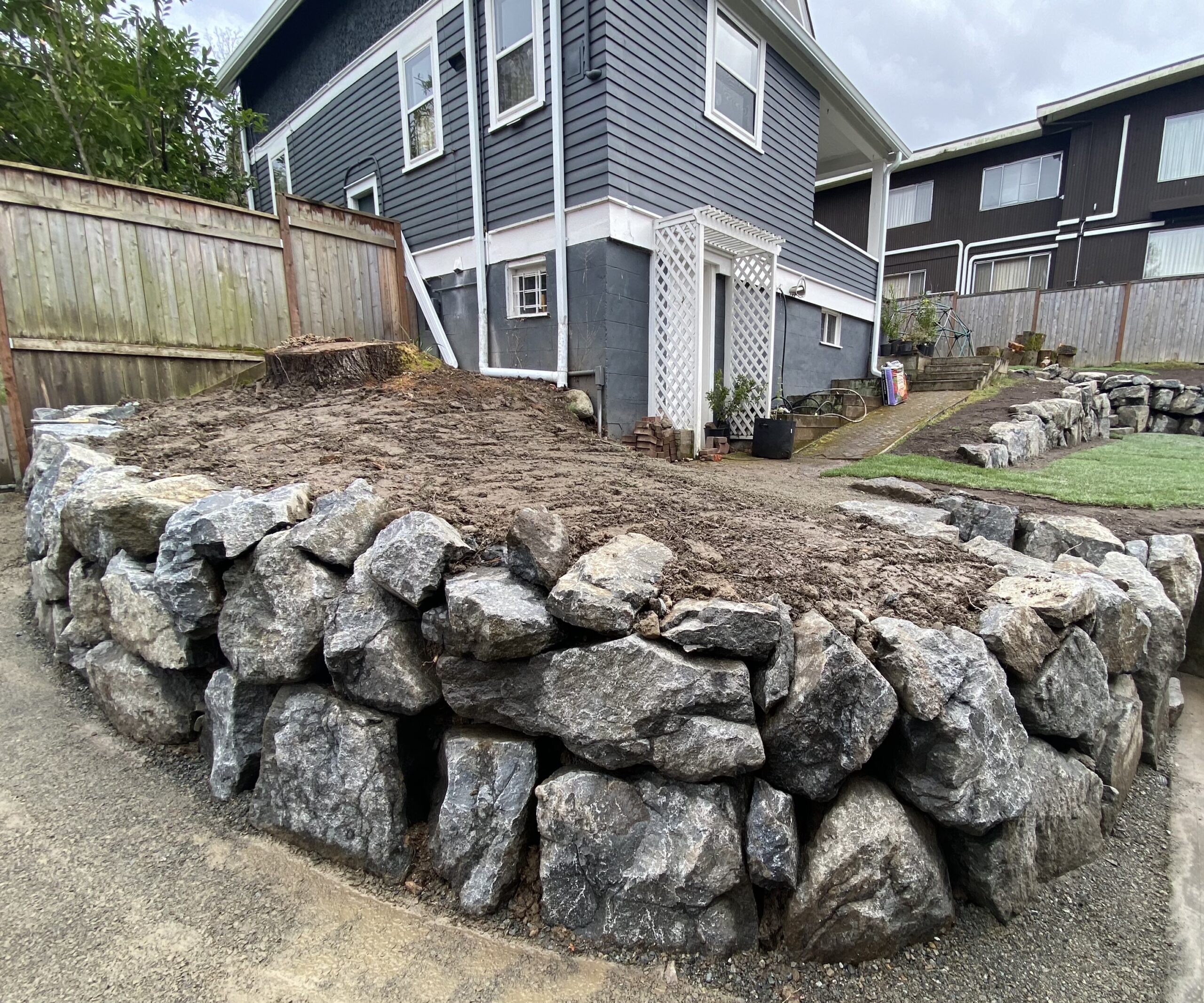 Rockery wall in front yard with curved design. Seattle, WA