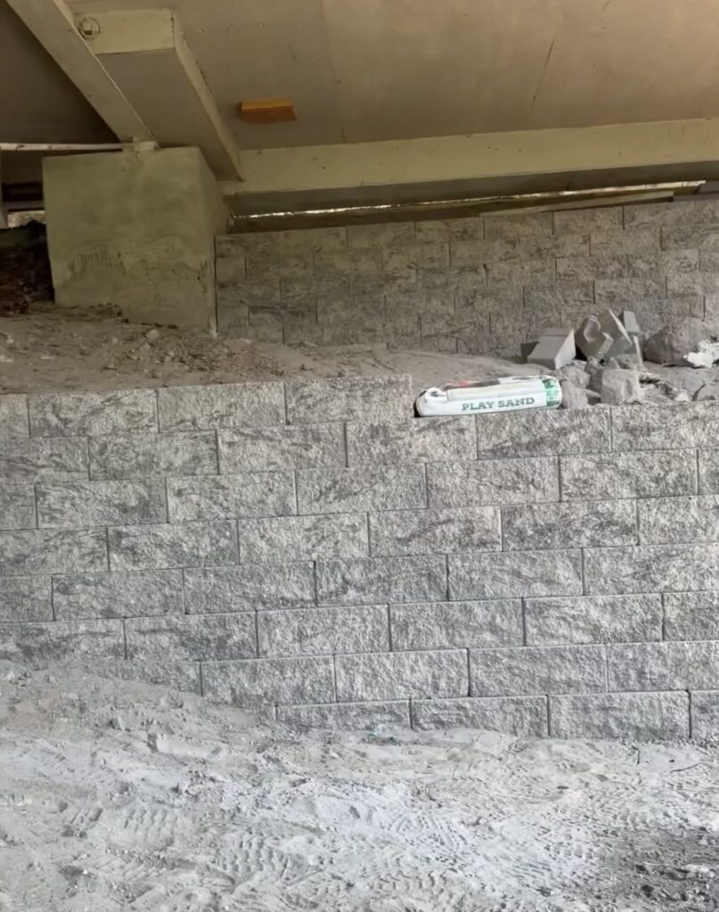 Two-tier segmental block retaining wall built from the bottom of the slope up beneath an elevated home in Seattle